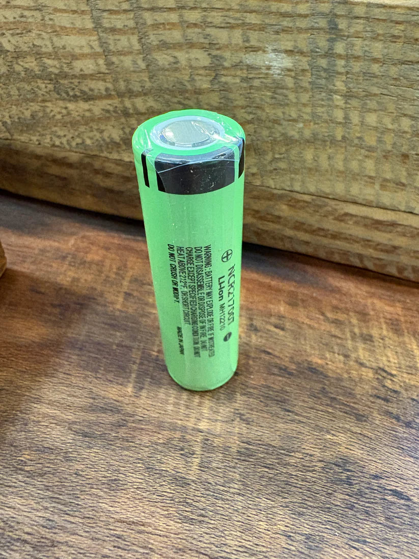 green battery on wood serface