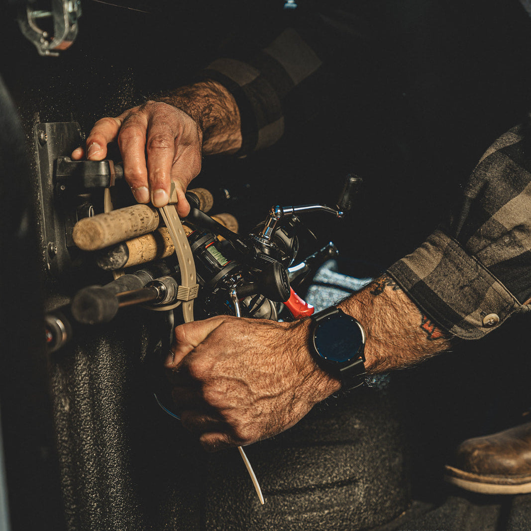 Close-up of hands working on a mechanical device with a dark background